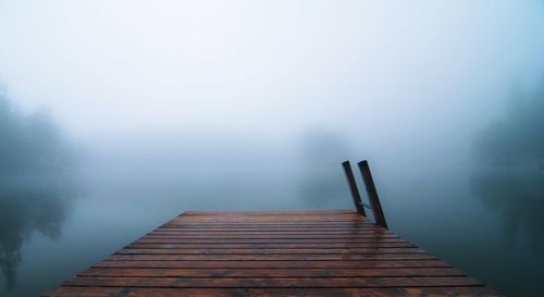 Pier over lake against sky