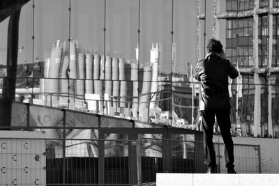 Rear view of man standing against building