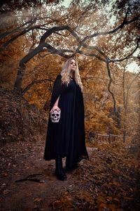 Full length of woman standing by tree