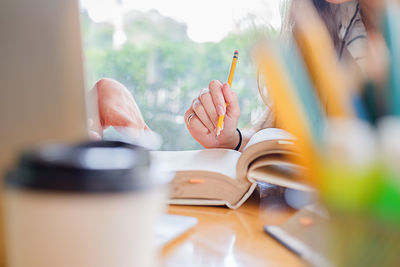 Close-up of hand studying at desk