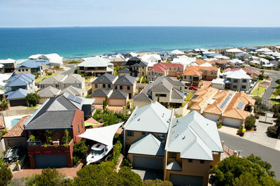 Houses by sea against sky in town