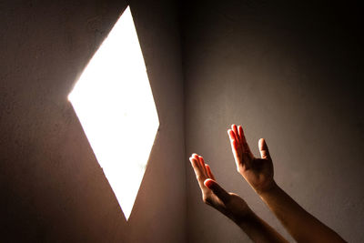 Close-up of praying hand holding illuminated light