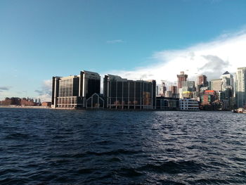 Modern buildings by sea against sky