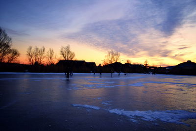 Scenic view of frozen lake against sky during sunset