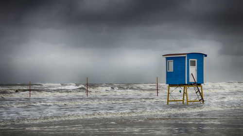 Lifeguard hut on beach against sky