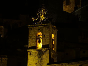 Low angle view of illuminated statue against building at night