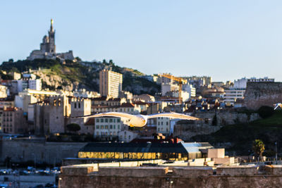 Buildings in city against clear sky