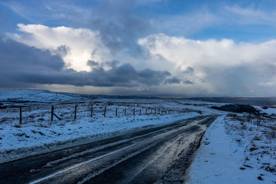 Snow covered road against sky