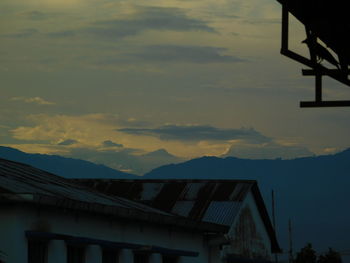 Low angle view of house against sky at sunset