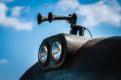 Close-up of old car against blue sky