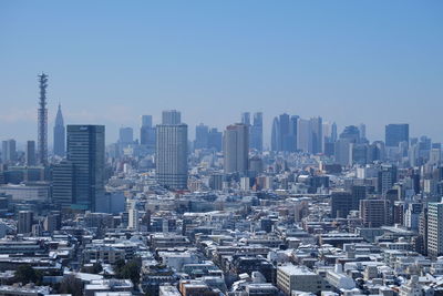 Aerial view of buildings in city against clear sky