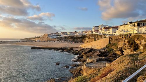 Panoramic view of beach by city against sky