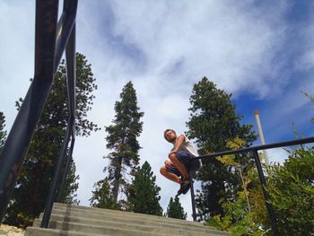 Low angle view of woman standing on tree