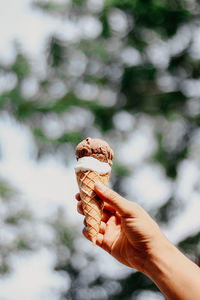 Close-up of hand holding ice cream cone outdoors