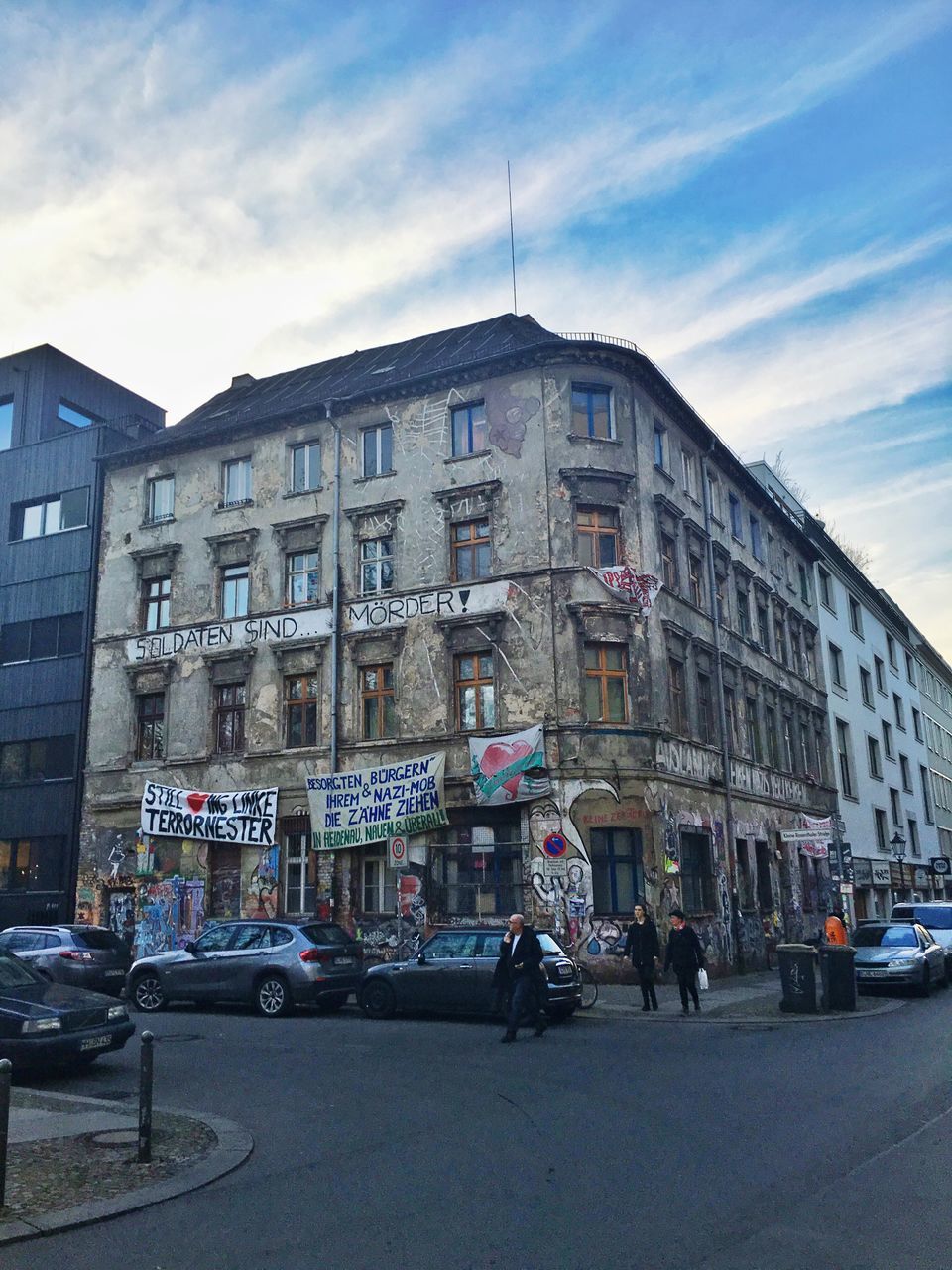 building exterior, architecture, built structure, transportation, car, street, land vehicle, city, mode of transport, sky, road, city life, city street, incidental people, building, outdoors, day, travel, traffic, cloud - sky