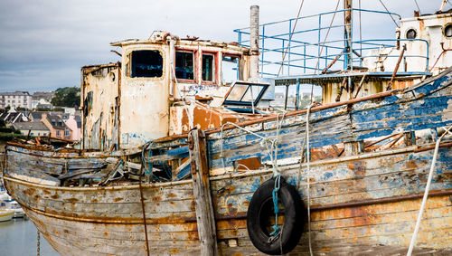 Abandoned boat moored against sky