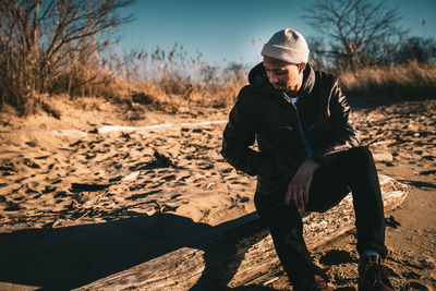 Full length of young man sitting on land