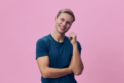 Portrait of young man standing against yellow background