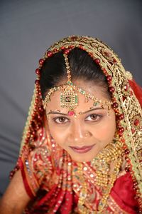 Close-up portrait of smiling young bride against curtain