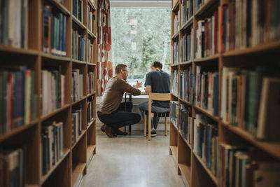 Professor explaining student in library at university