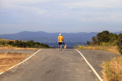 Rear view of man on road against sky