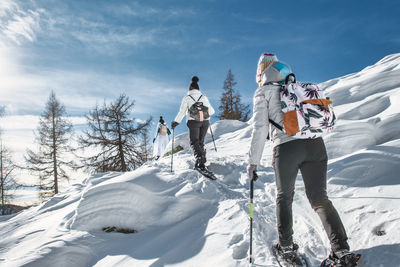 People skiing on snow covered landscape