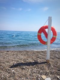 Red umbrella on beach against sky