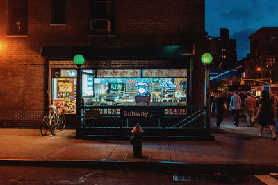 People standing in illuminated city at night