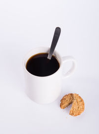 Coffee cup and cookies against white background