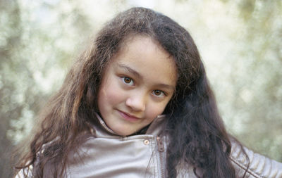 Portrait of smiling girl against trees