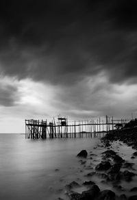 Pier over sea against sky at dusk