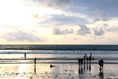 Silhouette people on beach against sky