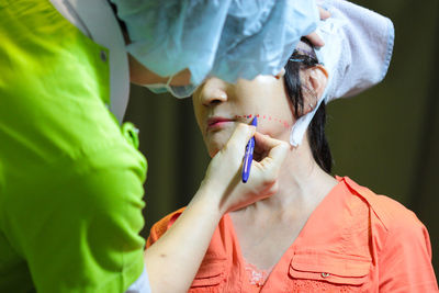 Doctor making markings on patient face in operating room