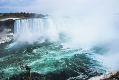 Scenic view of waterfall against sky