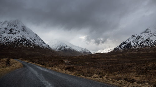 Scenic view of snowcapped mountains against cloudy sky