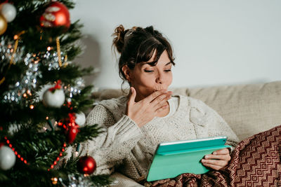 Young woman using mobile phone at home