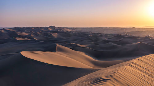 Scenic view of desert against sky during sunset