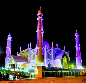 Low angle view of illuminated building against sky at night