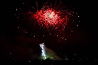 Low angle view of firework display at night