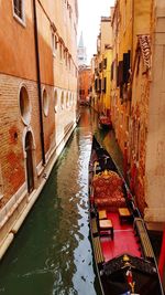 Canal amidst buildings in venice with gondola 