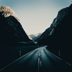 Road amidst mountains against clear sky