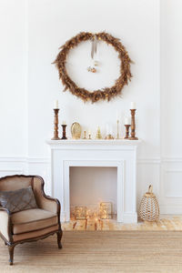 White fireplace decorated with a wreath for the holidays in a cozy home