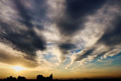 Silhouette of landscape against cloudy sky at sunset