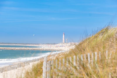 Lighthouse by sea against sky