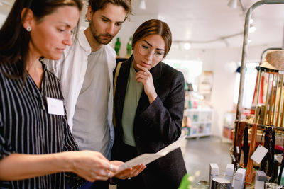 Saleswoman showing brochure to couple at fashion store