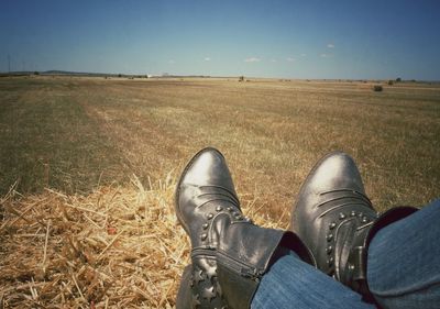 Low section of person standing on grassy field