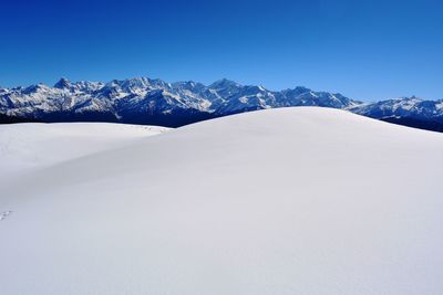 Scenic view of snowcapped mountains against clear blue sky