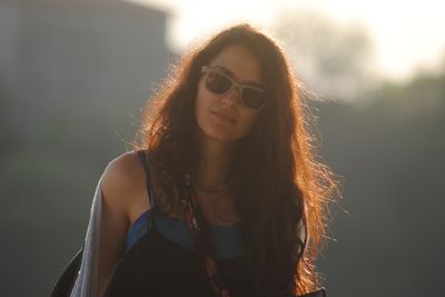 Portrait of young woman wearing sunglasses against sky