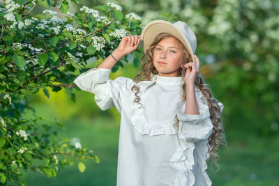 Portrait of a girl standing against tree