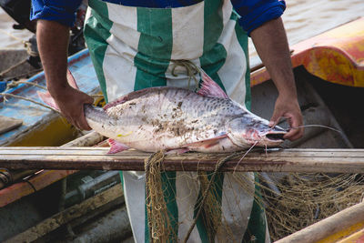 Full length of man holding fish for sale at market